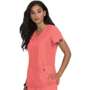 A coral medical top featuring a V-neck design and two front pockets. It has a logo on the sleeve.