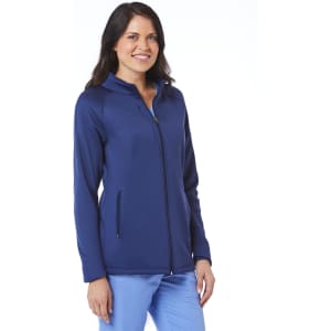 A woman is wearing a navy fleece jacket with a zip front and side pockets, featuring a logo.