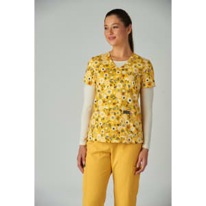 A floral print top in yellow and white, worn with long sleeves, paired with yellow trousers. Features a brand logo.