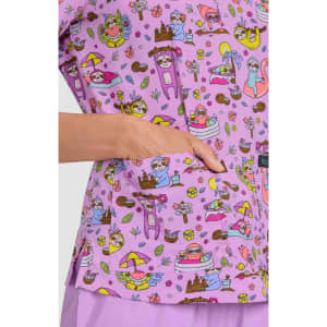 A vibrant purple top featuring a playful print with various whimsical characters and designs, including flowers and animals.