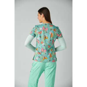 A floral-patterned top in teal with butterflies, paired with mint green pants. The top has a logo on it.