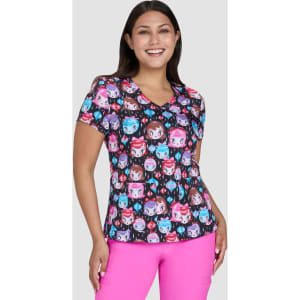 A colourful women's top featuring a pattern of cartoon-style faces in shades of pink, blue, and purple. It has a v-neck design.