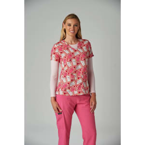 A pink patterned top featuring colourful designs, worn over a long-sleeve shirt, paired with pink pants.