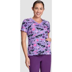 A short-sleeved purple top featuring a playful Halloween-themed print with various designs and a pocket.