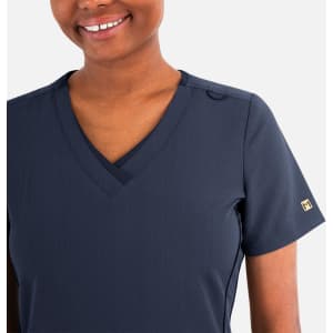 A navy blue women's layered V-neck top with a short sleeve and a discreet logo on the sleeve.