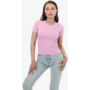 A pink fitted t-shirt displayed on a model, paired with light denim jeans. The shirt has a small logo.
