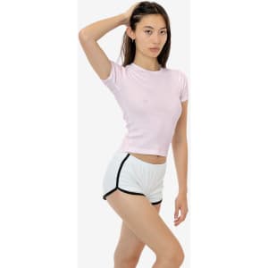 A light pink baby rib tee paired with white shorts featuring black trim, displayed on a model in a neutral setting.
