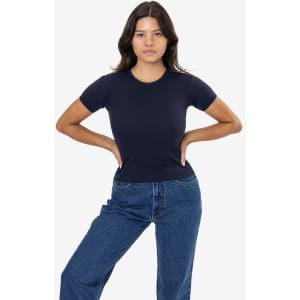 A navy blue baby rib tee is displayed on a model, paired with high-waisted denim jeans. The shirt has a fitted silhouette and short sleeves.