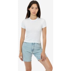 A white fitted t-shirt with short sleeves, displayed on a model wearing denim shorts. The product includes a logo.