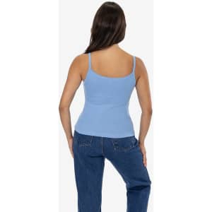 A fitted baby rib spaghetti tank top in light blue, displayed on a model with long hair, paired with denim jeans.