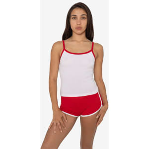 A model wears a white rib spaghetti tank top with red trim, paired with red shorts featuring white edges.