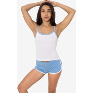 A woman poses in a white baby rib spaghetti tank top with light blue trim, paired with matching shorts.