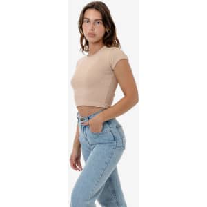 A model wearing a beige cap sleeve baby rib crop top paired with light blue jeans. The top features a fitted design.