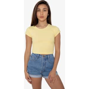 A model wearing a yellow cap sleeve baby rib crop top and denim shorts. The top has a fitted design and a slight stretch.