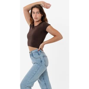A brown cap sleeve crop top paired with light blue high-waisted jeans, model posing against a plain background.