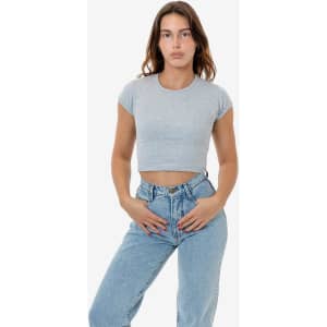 A grey cap sleeve crop top paired with high-waisted blue jeans, featuring a fitted design and a simple logo.