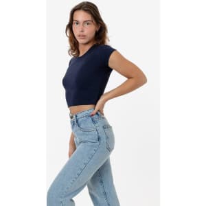A navy cap sleeve crop top is styled with light blue high-waisted jeans. The top features a fitted design.