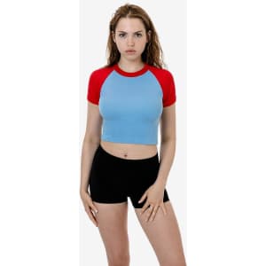 A short sleeve raglan tee in light blue with red sleeves, paired with black shorts. The model poses against a plain background.