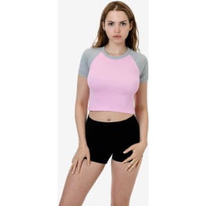 A short sleeve baby rib raglan tee in pink with grey sleeves, paired with black shorts; model is standing.