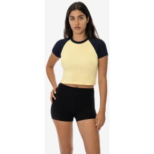 A light yellow short sleeve baby rib raglan tee with navy blue sleeves, paired with black shorts.