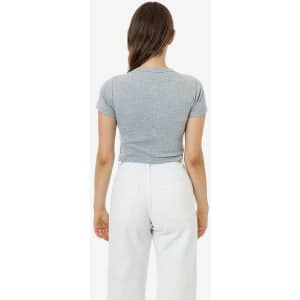A grey mid-length baby rib crewneck tee displayed from the back, paired with white trousers. The shirt has a fitted design.