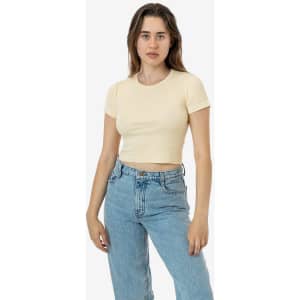 A model wearing a mid-length baby rib crewneck tee in a light yellow colour, paired with blue jeans.