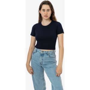 A navy mid-length baby rib crewneck tee displayed on a model, paired with light blue jeans. The shirt has a logo.
