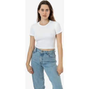 A white mid-length baby rib crewneck tee on a model, paired with blue jeans. The tee has a logo on it.