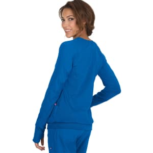 A woman wearing a bright blue Clarity Jacket, viewed from the back, smiling at the camera.