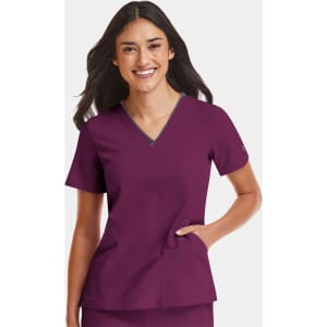 A woman is wearing a women's burgundy V-neck top with a grey contrast, featuring a logo.