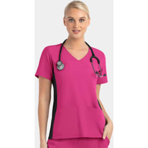 A woman wearing a pink mock wrap top with black contrast panels and a stethoscope around her neck.