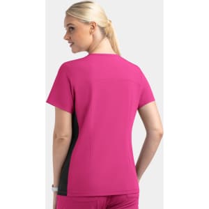 A women's mock wrap top in pink with contrast black panels, showcasing a sleek design from the back.
