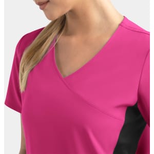 A women's mock wrap top in vibrant pink with contrast black panels, featuring a V-neck design.