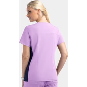 A mock wrap top in lavender with navy contrast panels and a logo on the back.