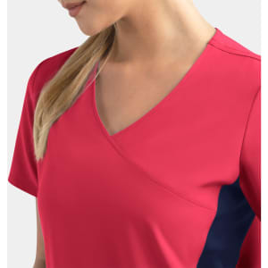 A women's mock wrap top in bright pink with contrast navy panels, featuring a deep V-neck design.