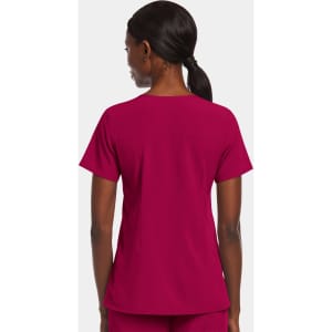 A women's mock wrap top in a vibrant magenta colour, featuring short sleeves and a simple design. It has a logo.