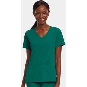 A women's mock wrap top in teal green with a v-neckline and two front pockets. The model is smiling.
