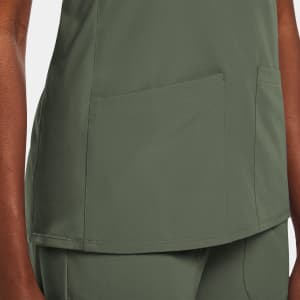 A green women's mock wrap top featuring two front pockets and a sleek design. The top has a subtle branding detail.