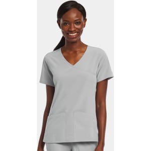 A woman wearing a light grey mock wrap top with two front pockets and a v-neckline.