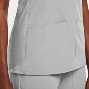 A women's mock wrap top in light grey with two front pockets and a sleek design.