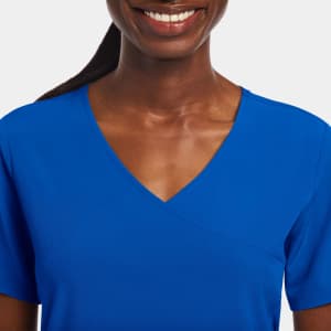 A vibrant blue women's mock wrap top features short sleeves and a v-neck design. The product includes a logo.