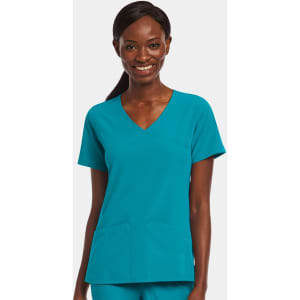 A mock wrap top in teal worn by a smiling woman, featuring two front pockets and a v-neck design.