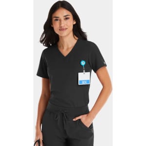 A women's black V-neck top with a pocket, worn with a badge holder. The top has a logo on it.