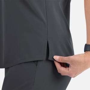 A close-up of a women's tuckable V-neck top in dark grey, highlighting the side split detail.