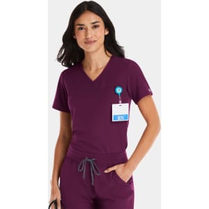 A women's tuckable v-neck top in deep burgundy, featuring a logo and a badge holder.