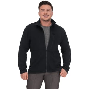 A man wearing a black jacket with a zip, featuring a grey shirt underneath and a pocket on the left side.