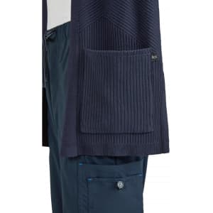 A navy Kori Sweater featuring ribbed textures and a large front pocket, with a branding logo.