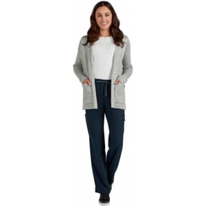 A woman wearing a grey Kori Sweater over a white top, paired with navy pants and black shoes.