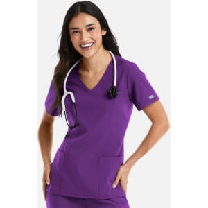 A woman models a purple double V-neck top, wearing a stethoscope around her neck. The top features two side pockets and a logo.