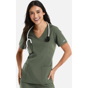 A woman wearing a green double V-neck top with a stethoscope around her neck and pockets. The top has a logo.